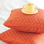 cup lying on pillows on the bed